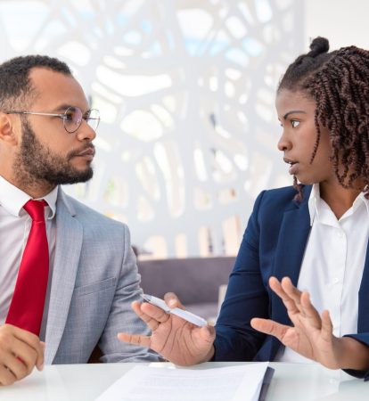 Businessman and businesswoman discussing contract Businessman and businesswoman discussing contract. Young African American business colleagues sitting in office and working with papers. Paperwork concept