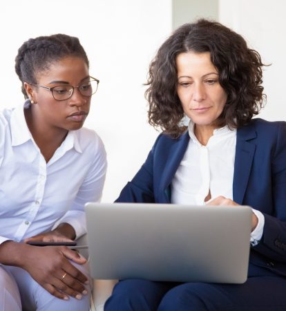 Serious businesswomen watching presentation together Serious businesswomen watching presentation together. Business women sitting in armchairs, using laptop, looking at screen. Teamwork concept
